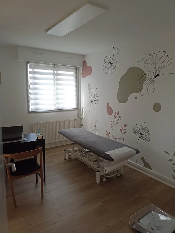 La salle de bilan d'Angèle Payen: la table de soin, le parquet chêne et la fresque de fleurs au trait noir